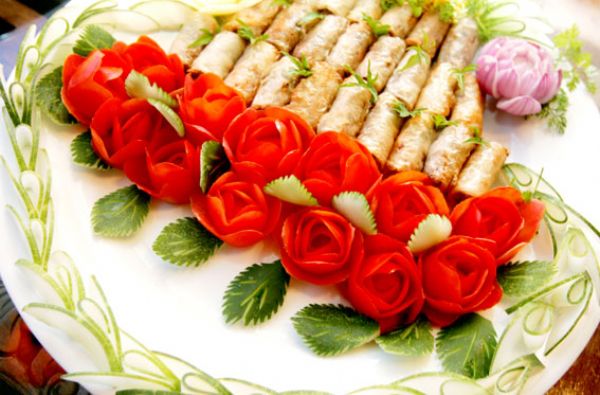 Spring rolls are decorated with roses made of tomatoes